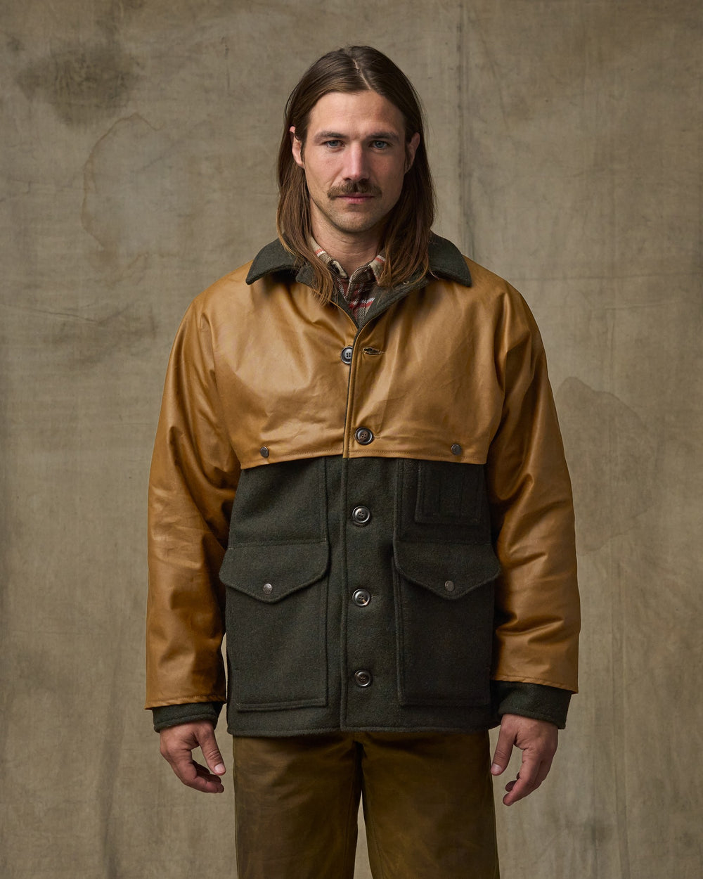 image of a model wearing Filson's Mackinaw Wool Caped Cruiser Jacket - Peat Black / Dark Tan