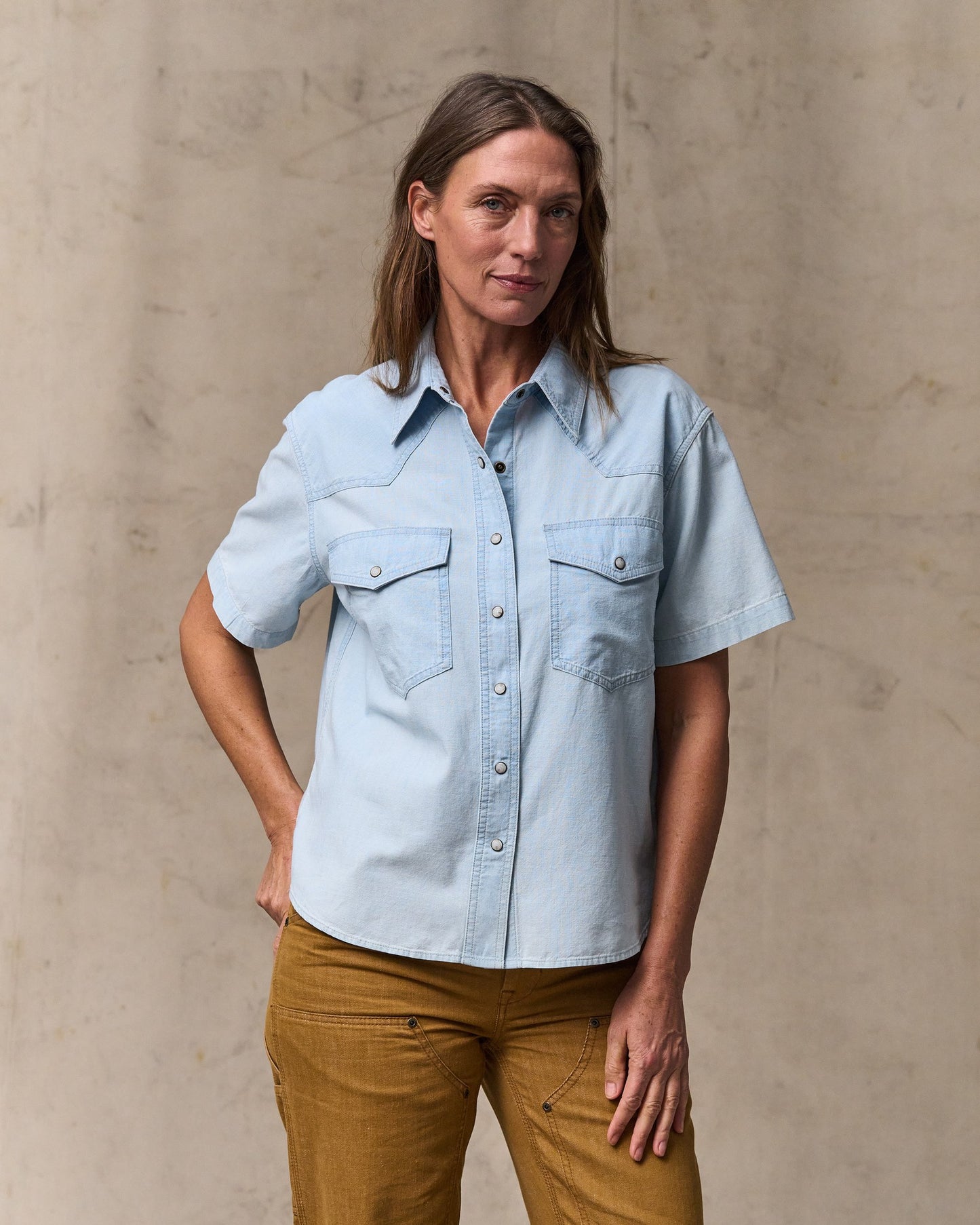 image of a model wearing Filson's Women's Short Sleeve Chambray Western Shirt - Light Indigo|Model is 5'10" wearing a size medium