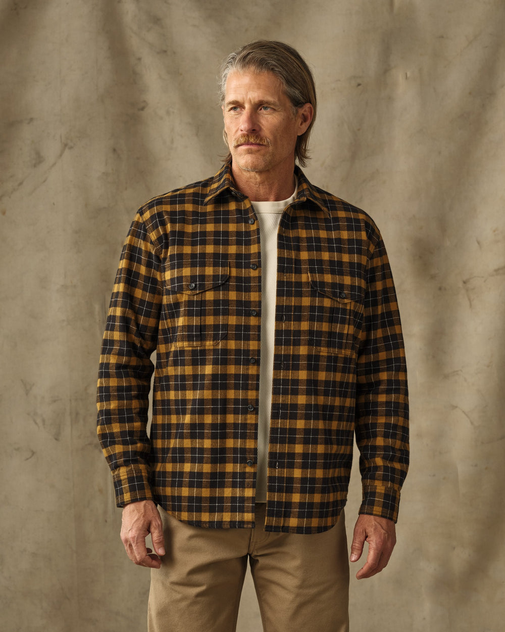 image of a model wearing Filson's Alaskan Guide Shirt - Black / Gold Plaid