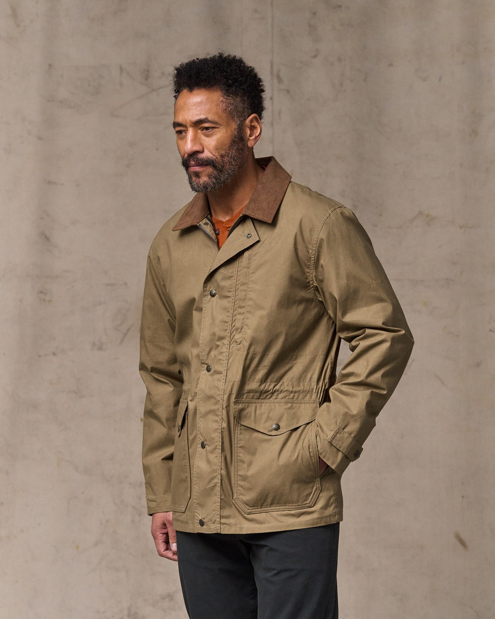 image of a model wearing Filson's Dry Wax Mile Marker Coat - Dark Beige