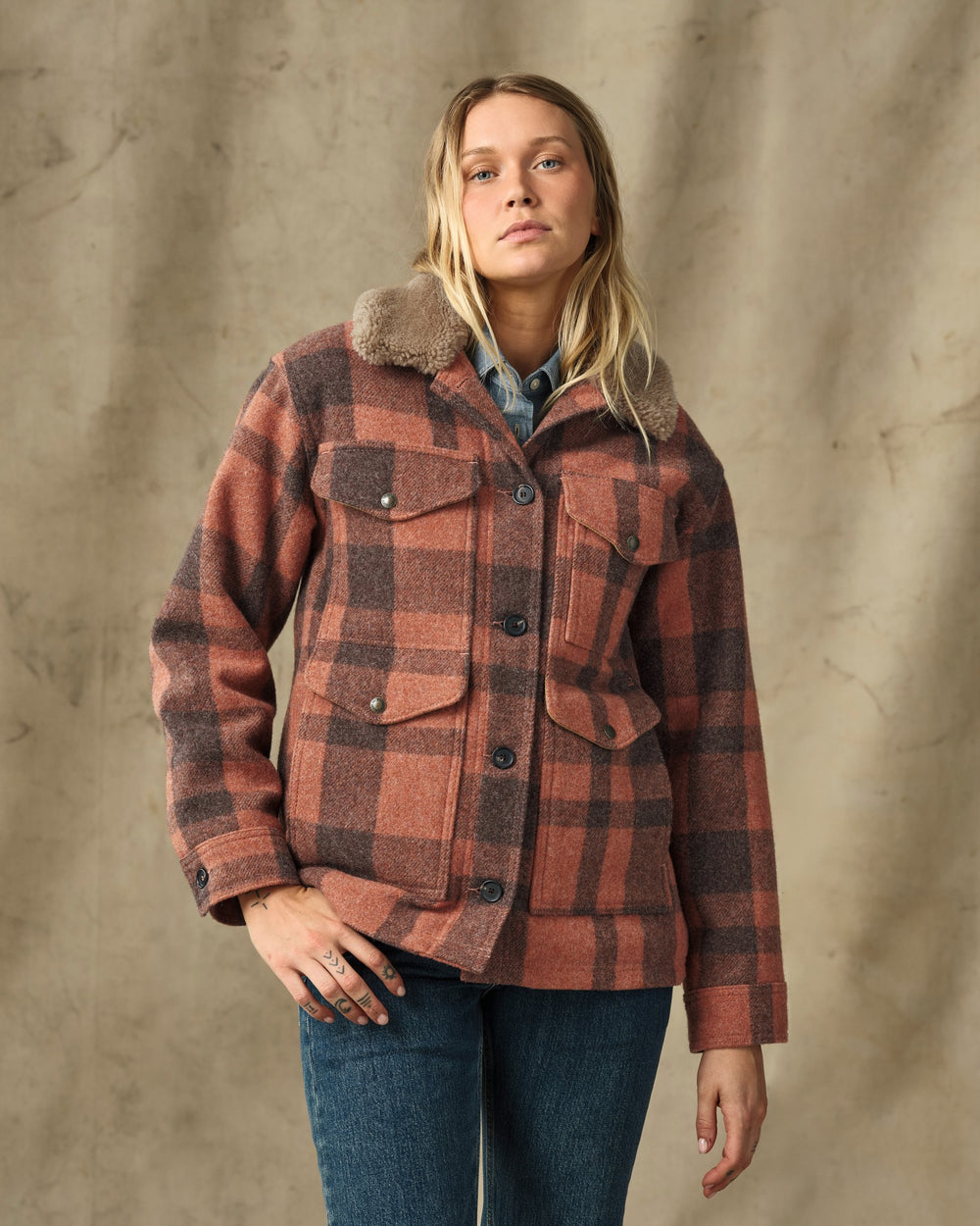 image of a model wearing Filson's Women's Mackinaw Wool Shearling Cruiser Jacket - Rusty Pink / Dark Brown Plaid