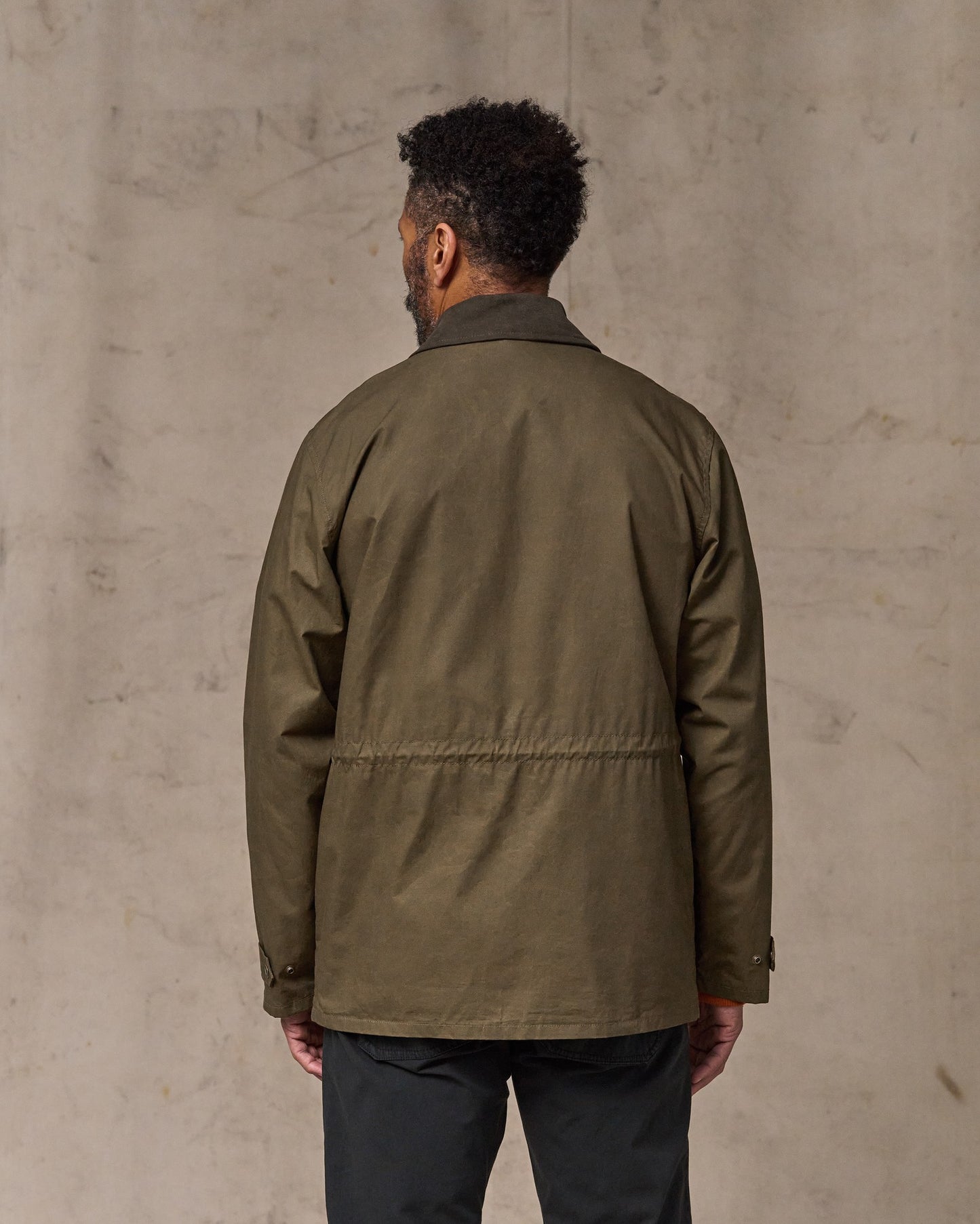 image of a model wearing Filson's Dry Wax Mile Marker Coat - Burnt Olive