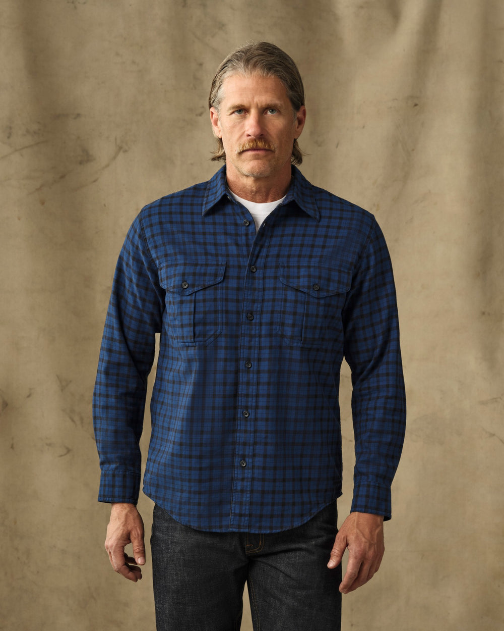 image of a model wearing Filson's Lightweight Alaskan Guide Shirt - Deep Blue / Black Plaid
