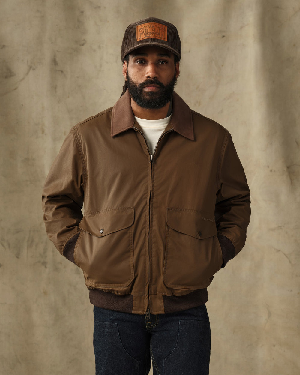 image of a model wearing Filson's Cover Cloth Bomber Jacket - Dark Tan