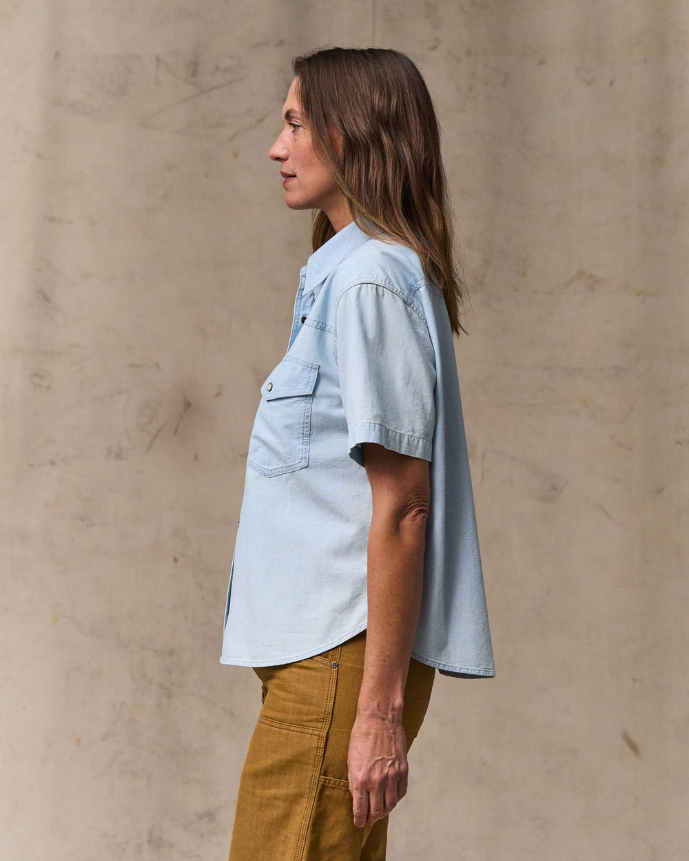 image of a model wearing Filson's Women's Short Sleeve Chambray Western Shirt - Light Indigo