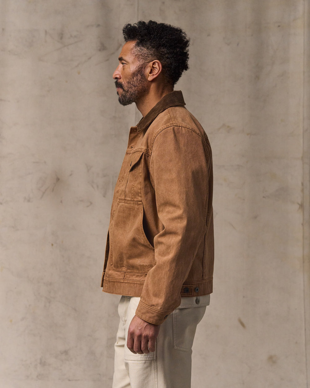 image of a model wearing Filson's Rustic Canvas Short Cruiser Jacket - Whiskey