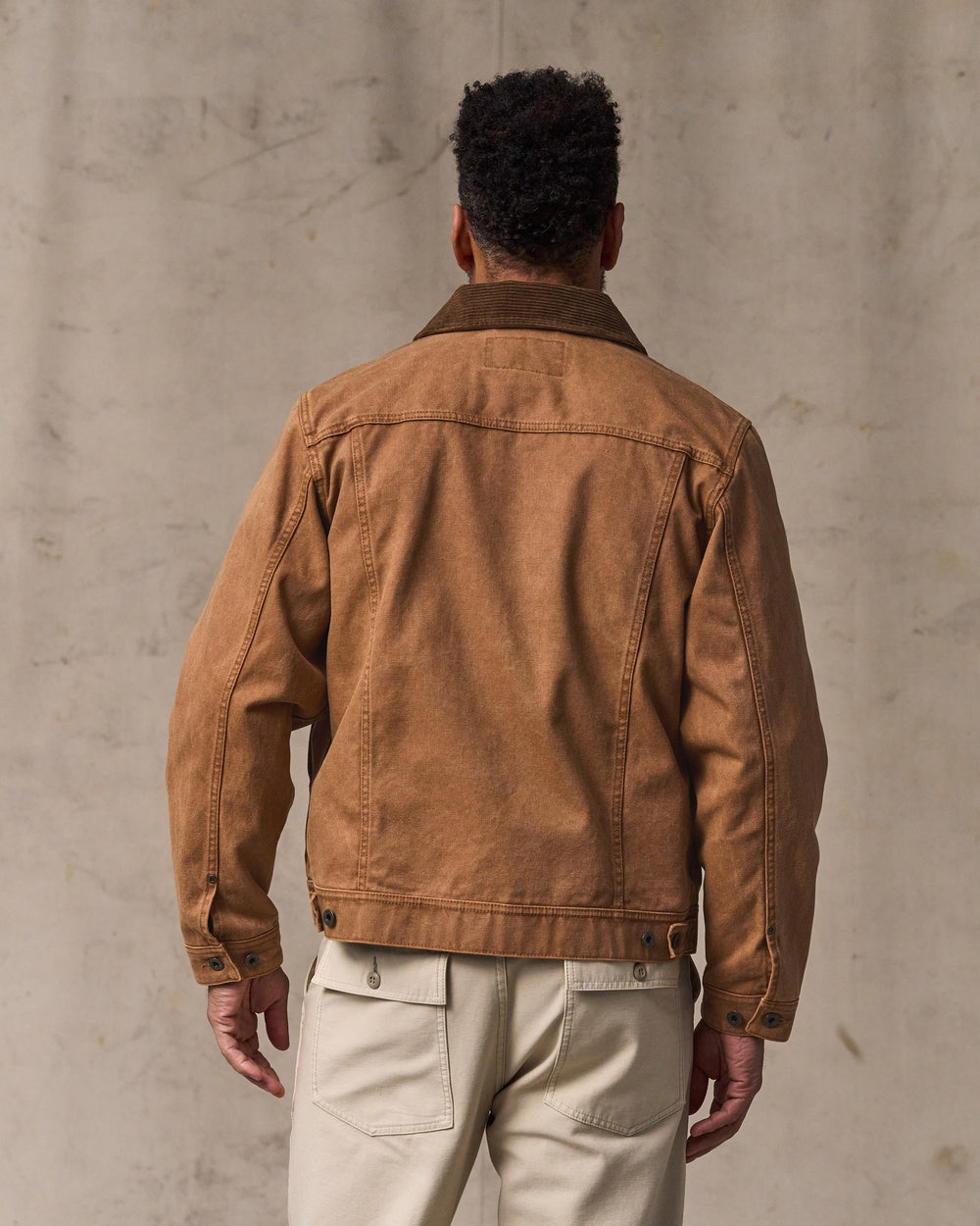image of a model wearing Filson's Rustic Canvas Short Cruiser Jacket - Whiskey