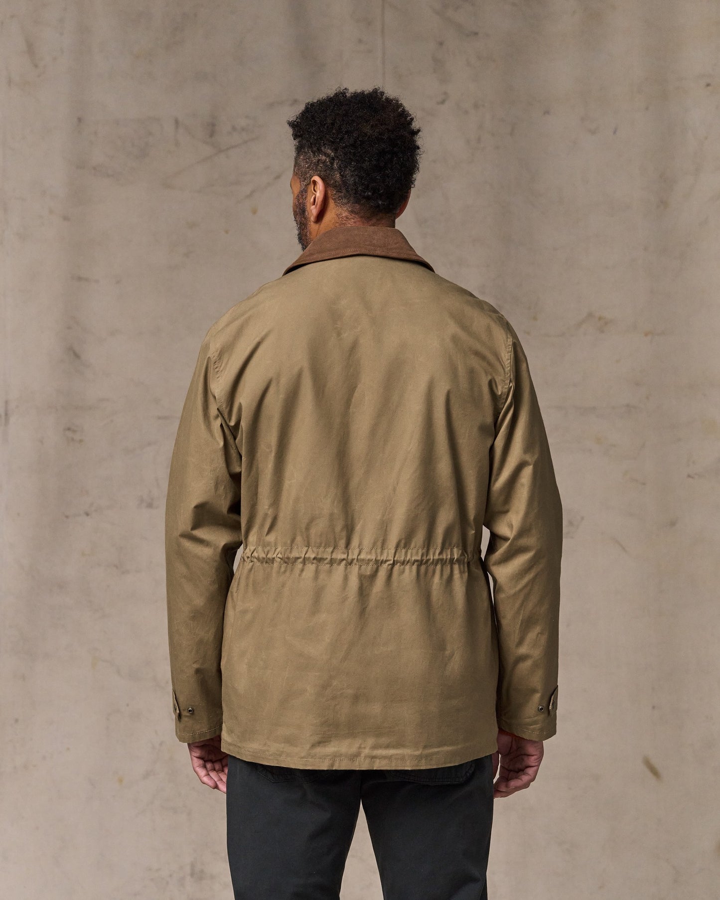 image of a model wearing Filson's Dry Wax Mile Marker Coat - Dark Beige