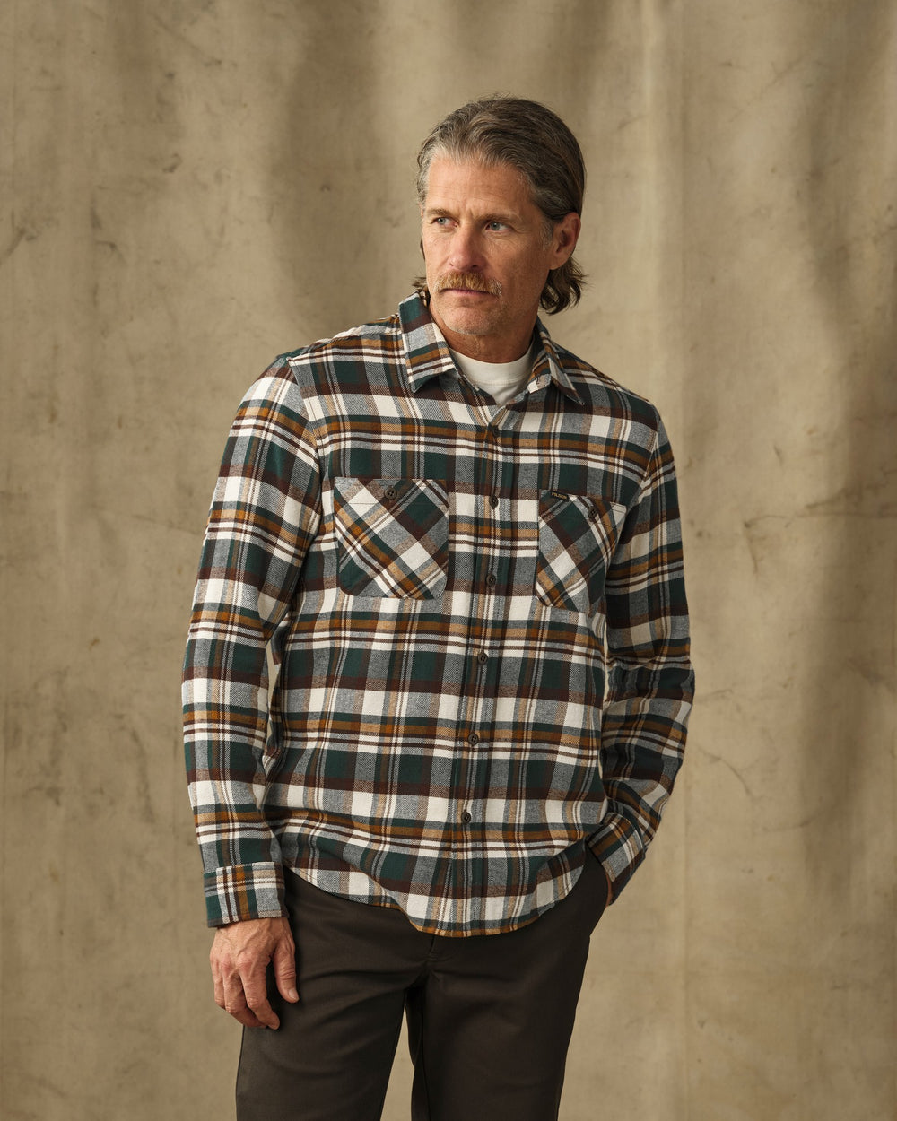 image of a model wearing Filson's Rangeland Flannel Shirt - Green / Bronze Plaid